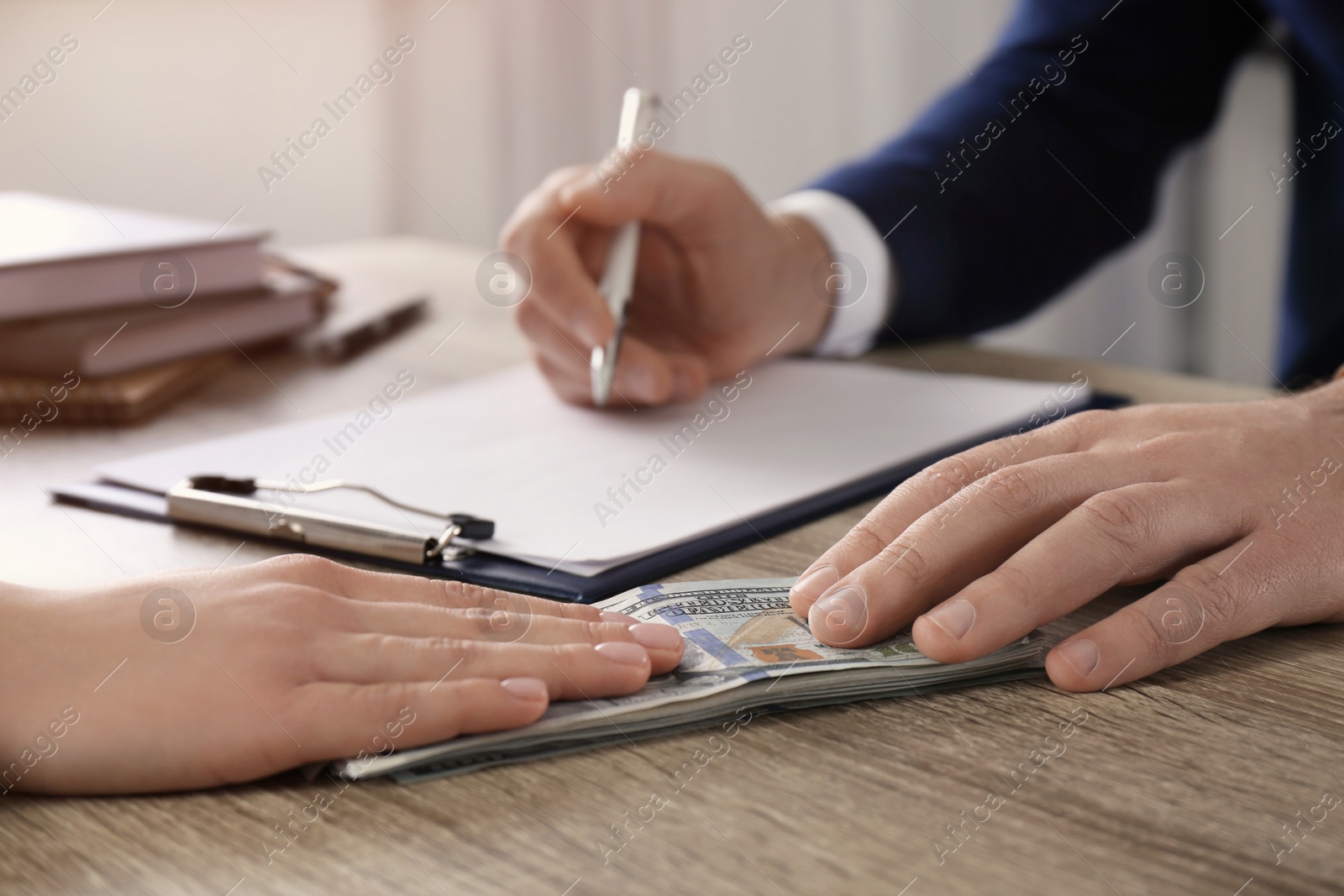 Photo of Woman giving bribe to man at table in office, closeup