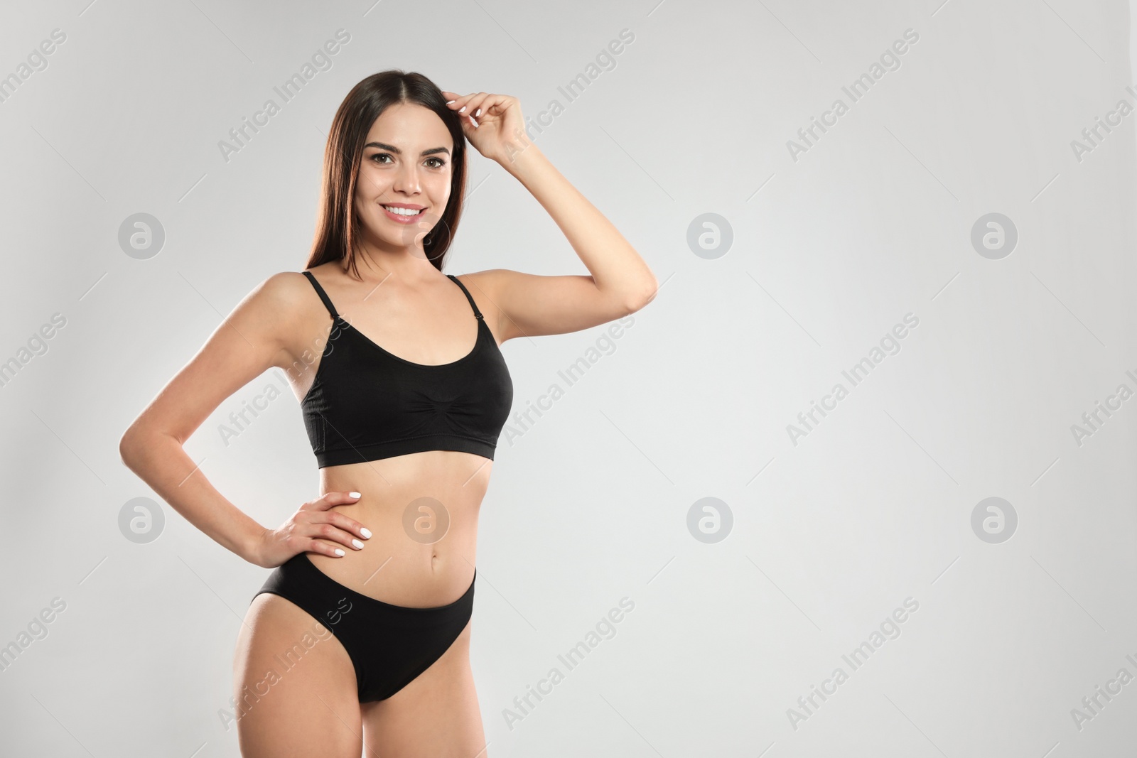 Photo of Portrait of attractive young woman with slim body in swimwear on white background. Space for text