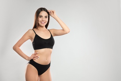 Photo of Portrait of attractive young woman with slim body in swimwear on white background. Space for text