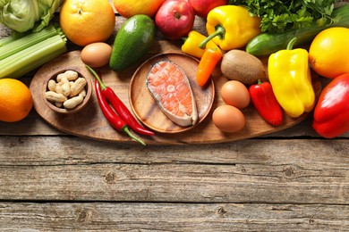 Photo of Healthy meal. Different vegetables and raw salmon on wooden table, flat lay. Space for text