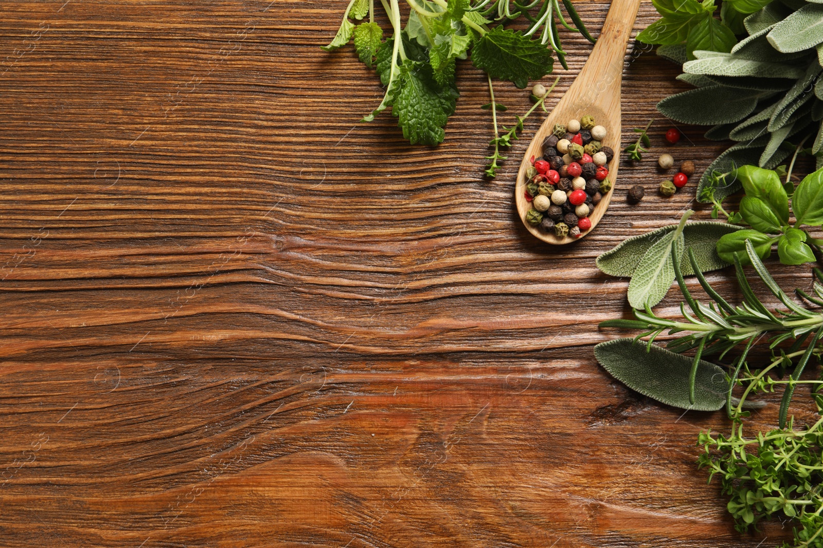 Photo of Different fresh herbs and spices on wooden table, flat lay. Space for text