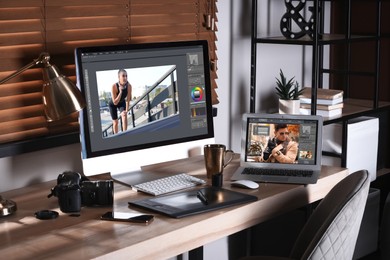 Retoucher's workplace. Computer and laptop with photo editor applications, camera, graphic tablet on table indoors