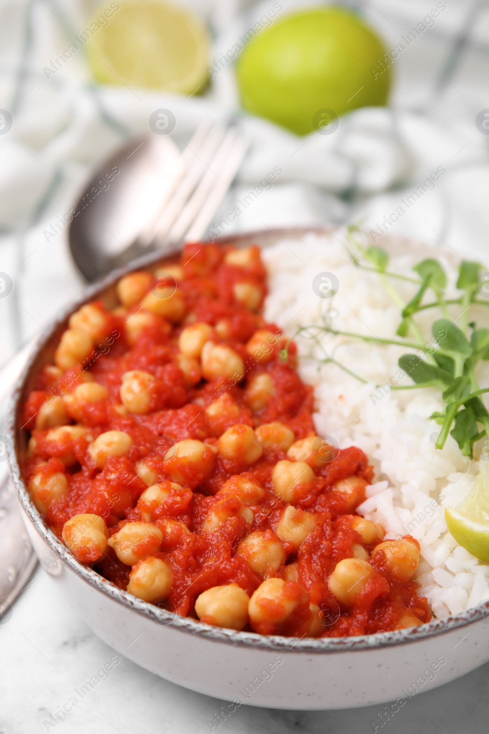 Photo of Delicious chickpea curry with rice in bowl on white marble table, closeup