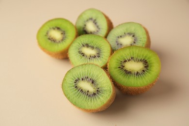 Halves of fresh kiwis on beige background