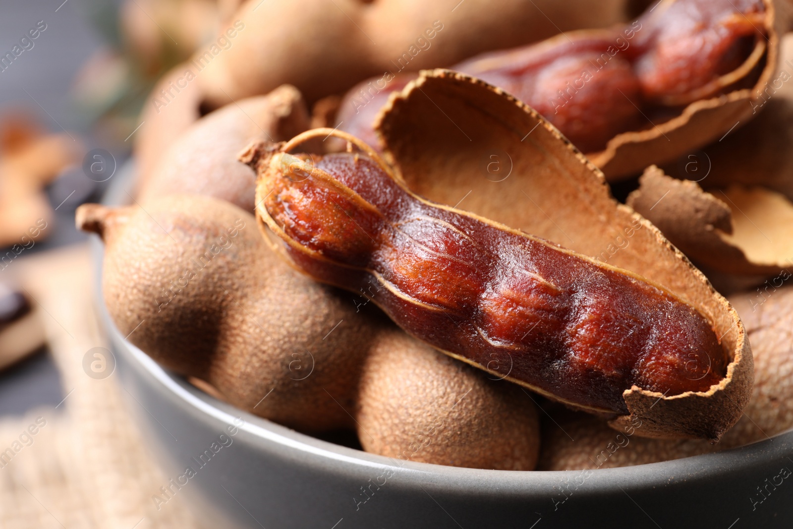 Photo of Delicious ripe tamarinds in ceramic bowl , closeup