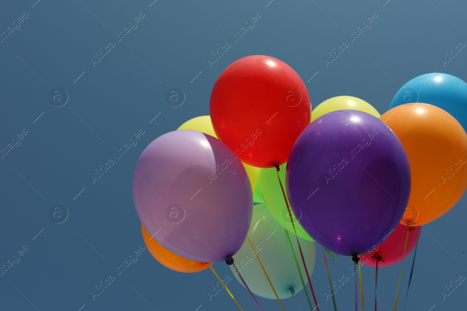 Photo of Bunch of colorful balloons against blue sky