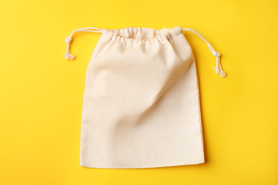 Photo of Cotton eco bag on yellow background, top view