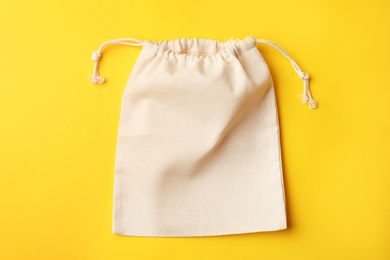 Cotton eco bag on yellow background, top view