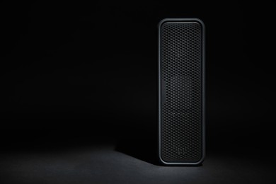 One portable bluetooth speaker on black background, space for text. Audio equipment
