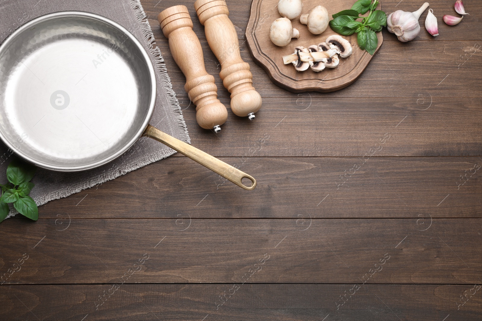 Photo of Flat lay composition with empty frying pan and fresh products on wooden table, space for text