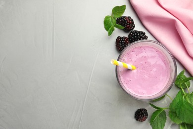 Photo of Delicious blackberry smoothie in glass and berries on white table, flat lay. Space for text