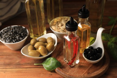 Photo of Different cooking oils and ingredients on wooden table