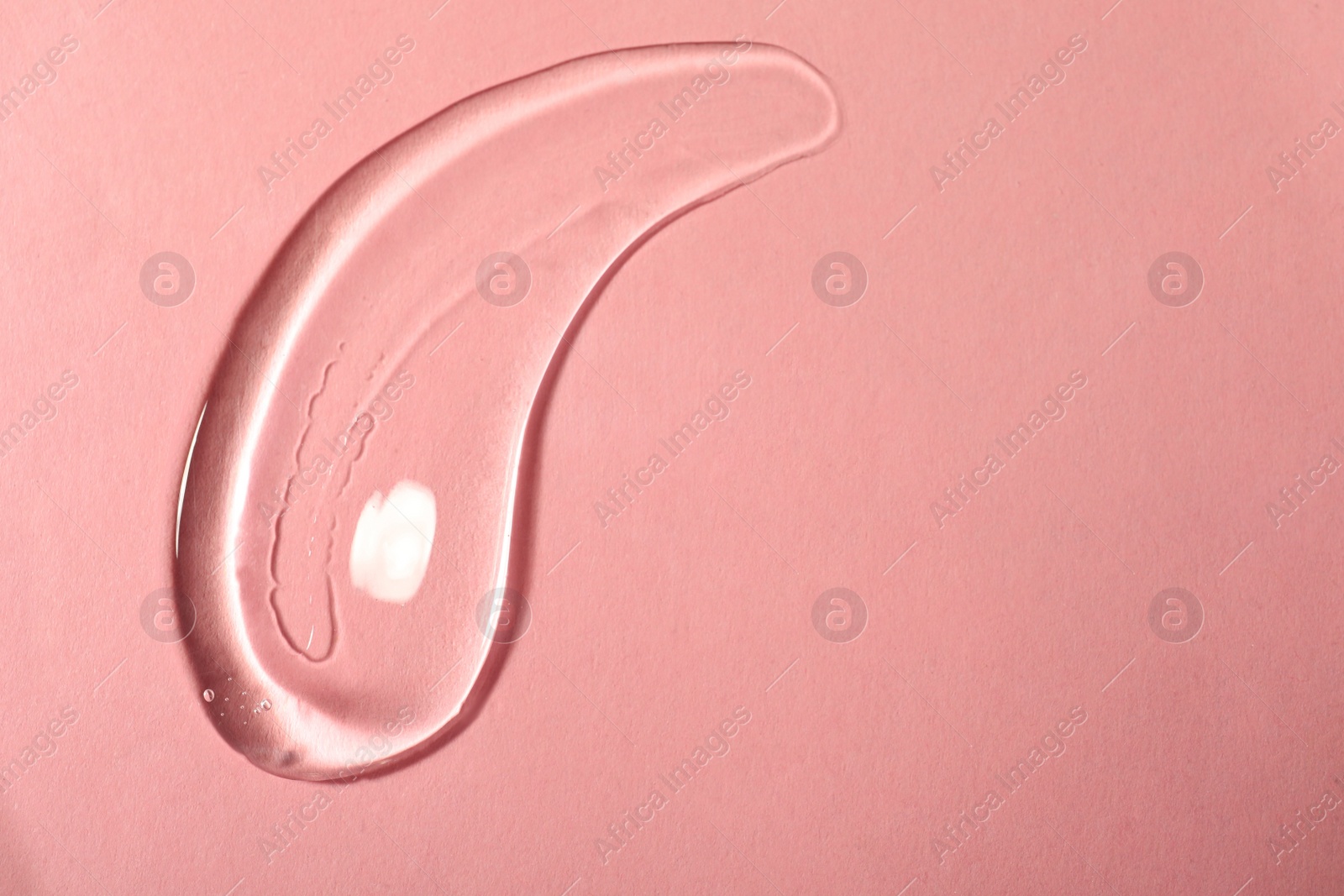 Photo of Sample of transparent cosmetic gel on pink background, top view. Space for text