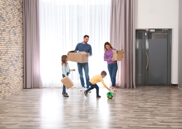Happy family with moving boxes in their new house