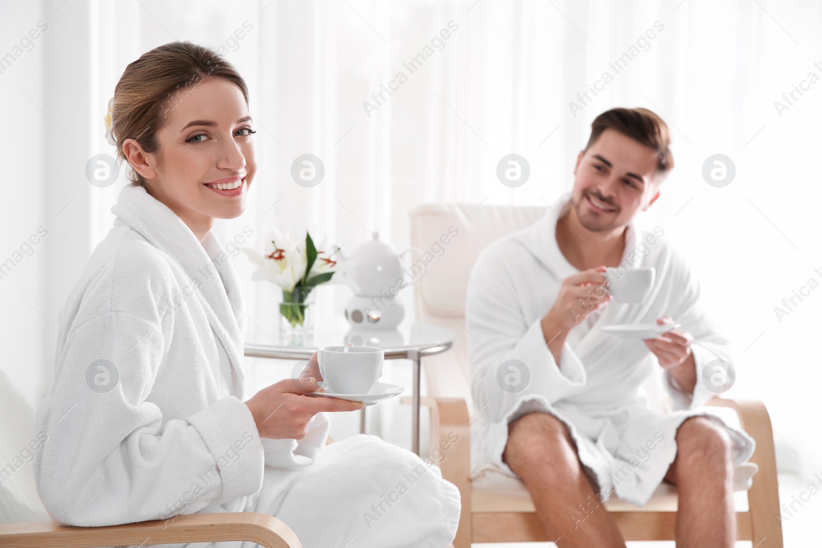 Photo of Romantic young couple with tea in spa salon