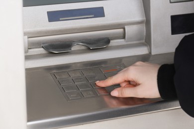 Woman using modern grey cash machine, closeup