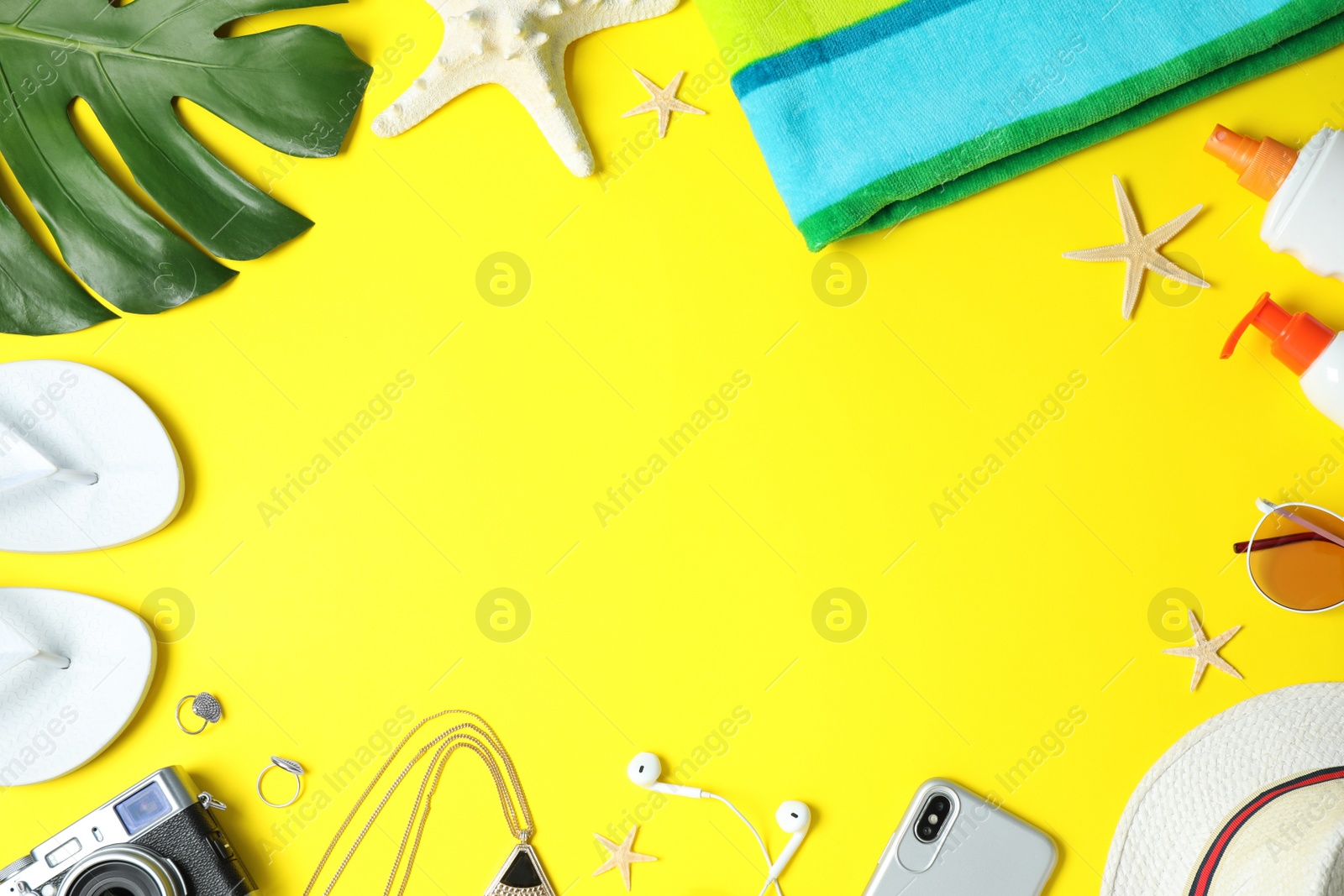 Photo of Flat lay composition with beach accessories on yellow background, space for text