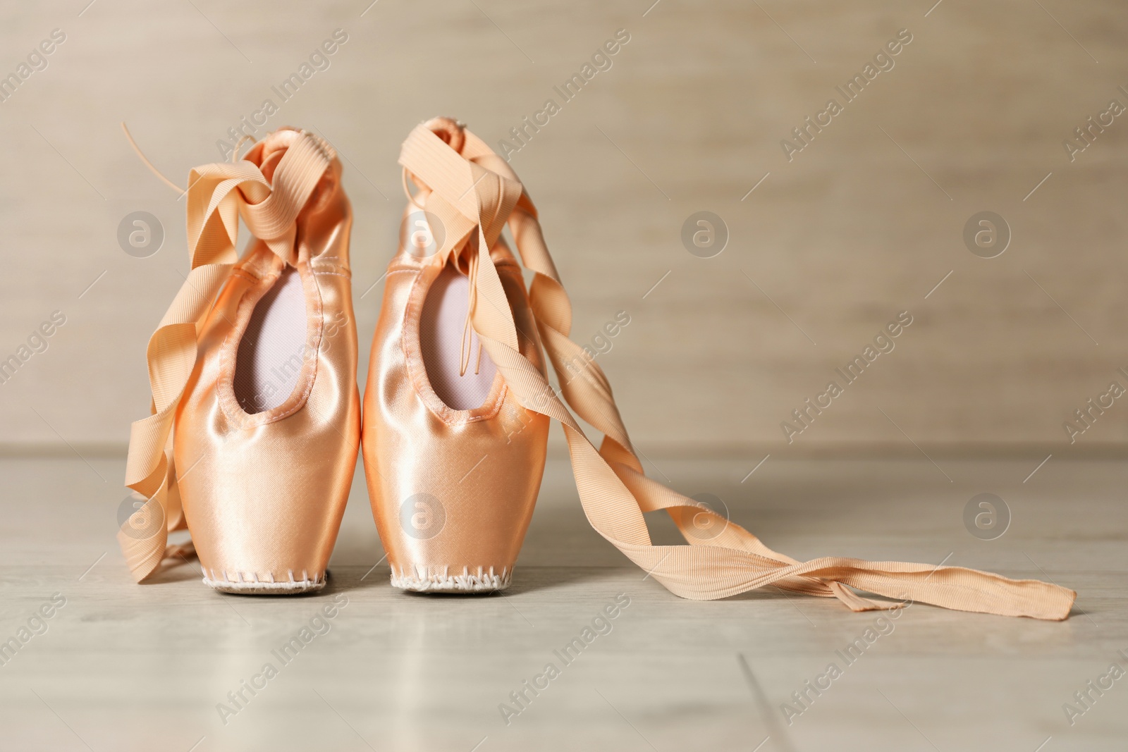 Photo of Ballet shoes. Elegant pointes on wooden floor indoors, space for text