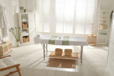 Stylish spa salon interior with massage table