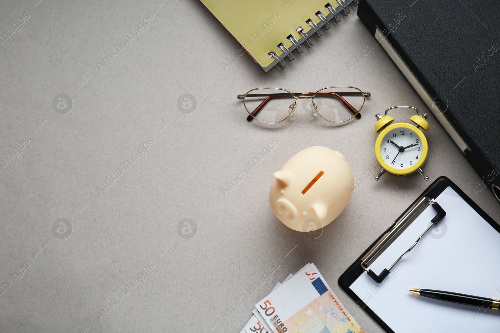 Photo of Flat lay composition with piggy bank and banknotes on grey background. Space for text