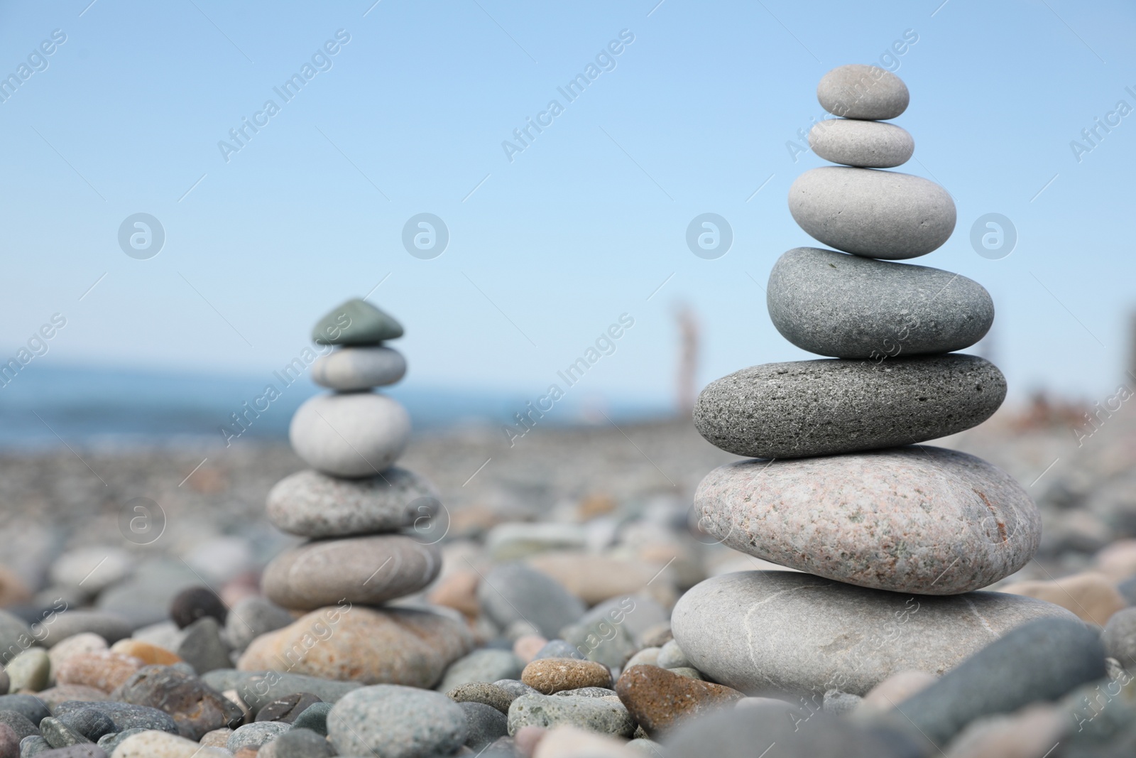 Photo of Stack of stones on beach against blurred background, closeup. Space for text