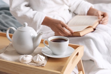 Woman with cup of hot tea at home, closeup