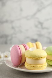 Delicious colorful macarons on grey table, closeup