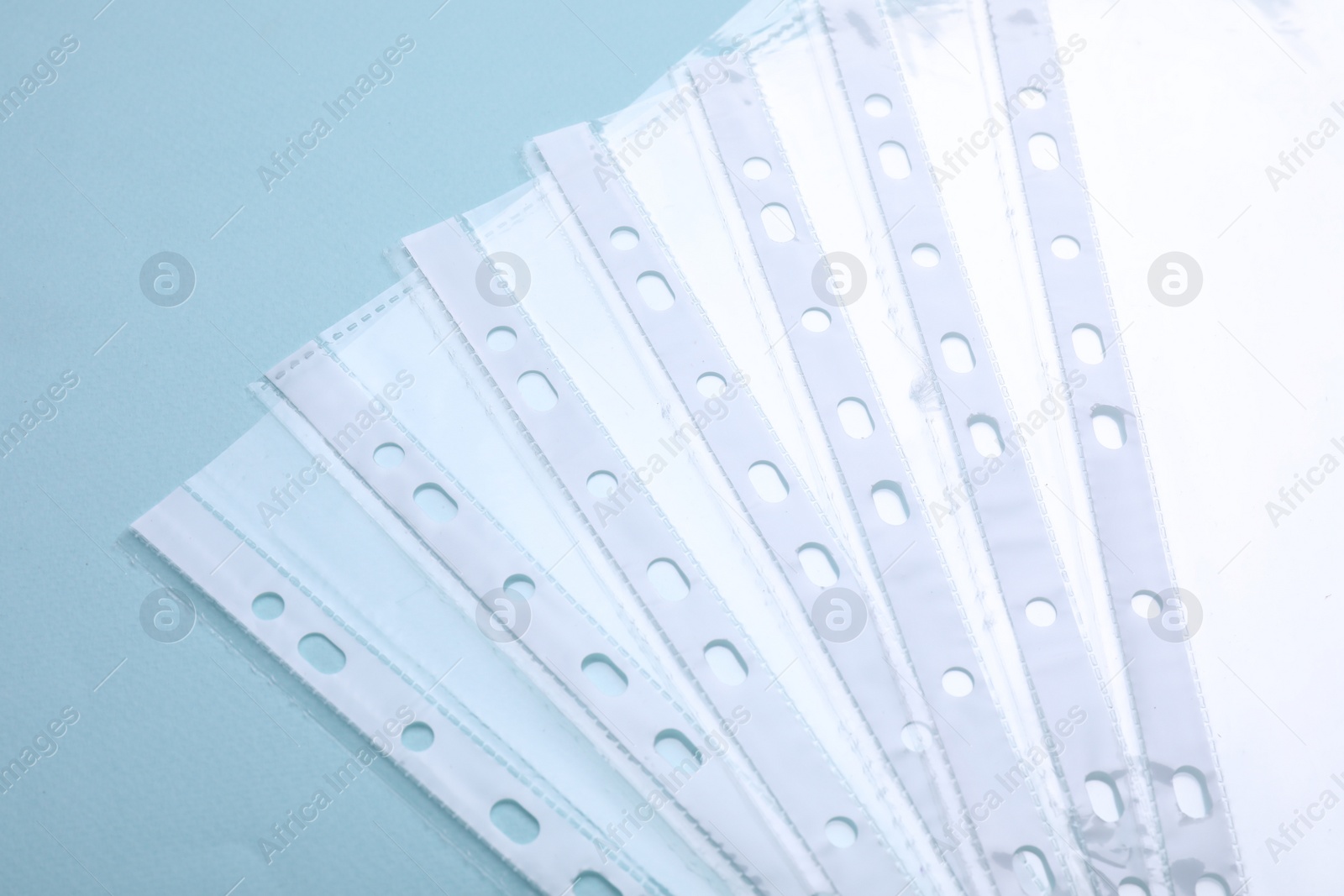 Photo of Empty punched pockets on turquoise background, flat lay