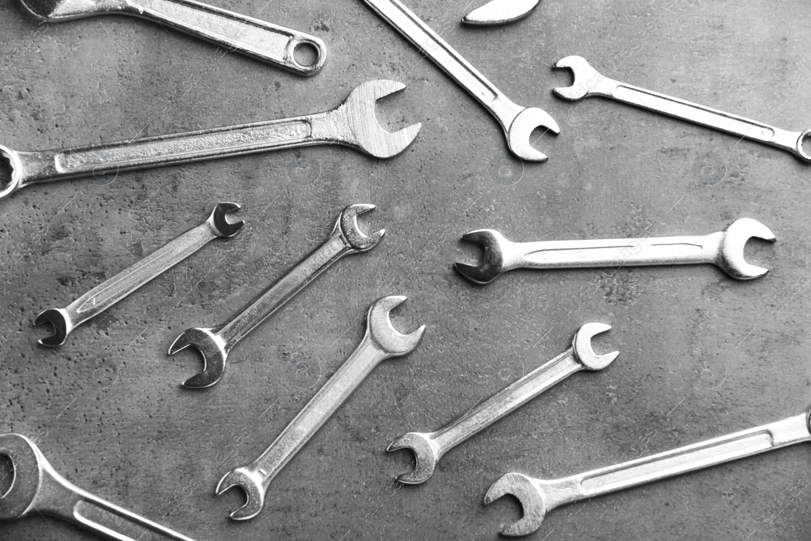 Photo of New wrenches on grey background, top view. Plumber tools