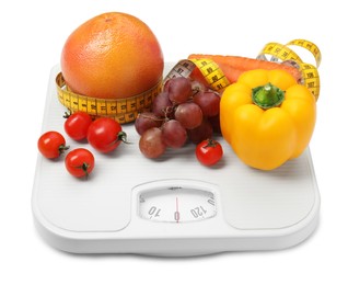 Photo of Scales, vegetables and measuring tape on white background