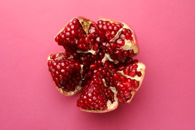 Photo of Cut fresh pomegranate on pink background, top view