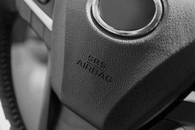 Photo of Safety airbag sign on steering wheel inside car, closeup