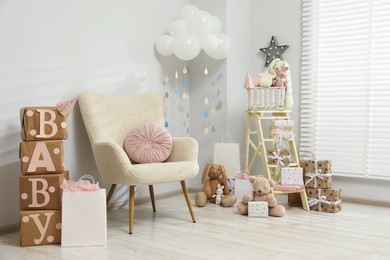 Photo of Baby shower party. Festive decor, gift boxes and toys in stylish room