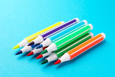 Many bright colorful markers on light blue background