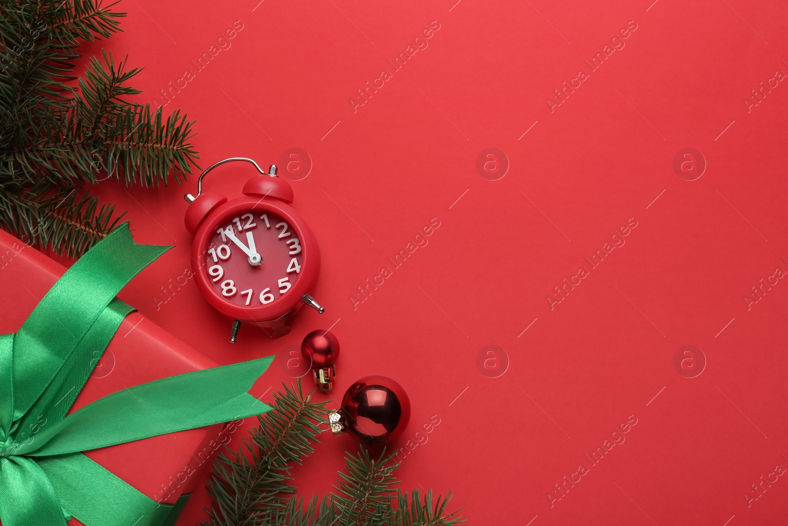 Photo of Flat lay composition with alarm clock and gift on red background, space for text. Boxing day