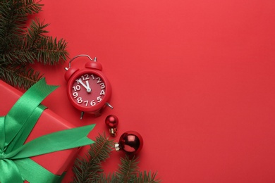 Flat lay composition with alarm clock and gift on red background, space for text. Boxing day