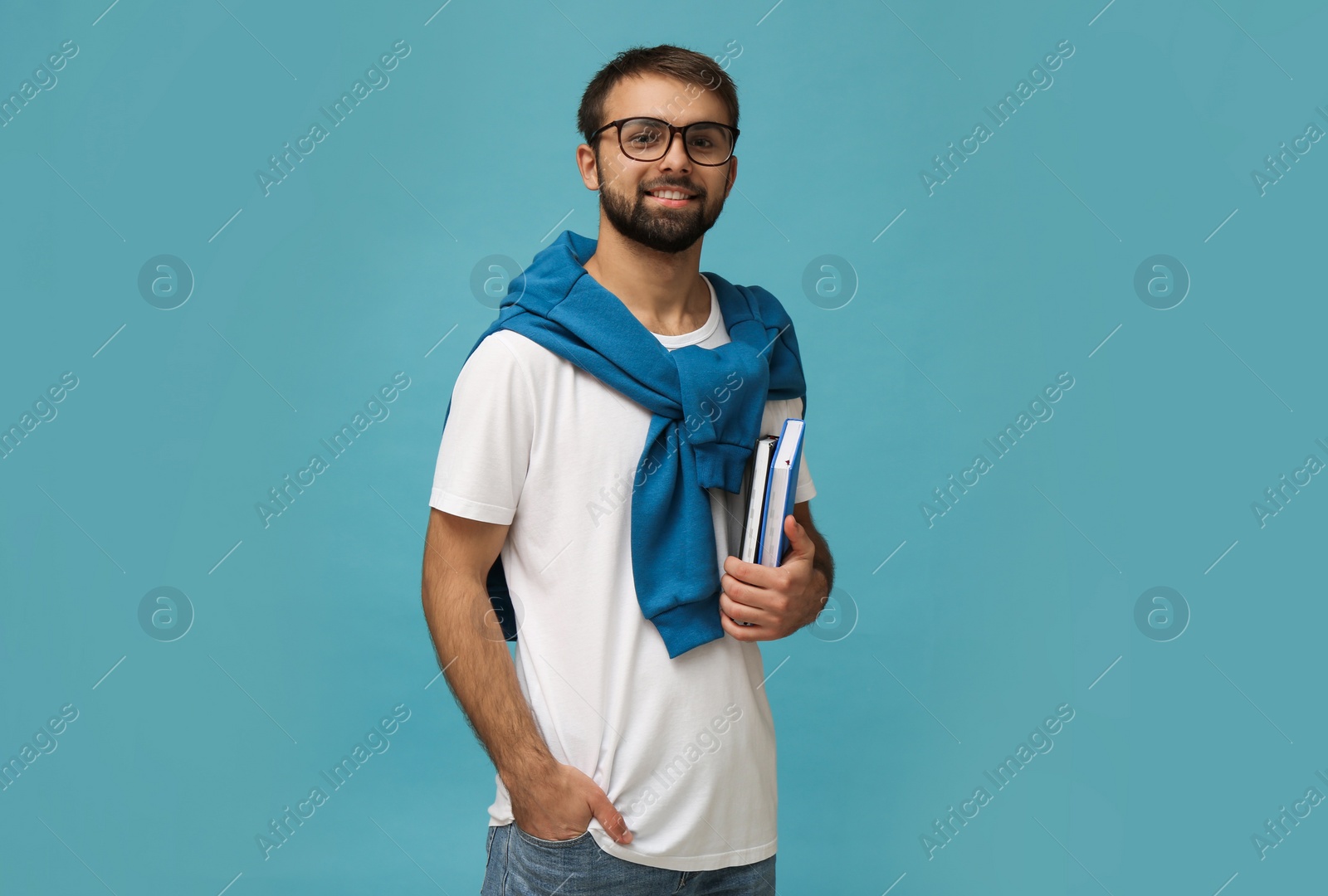 Photo of Student with books on light blue background