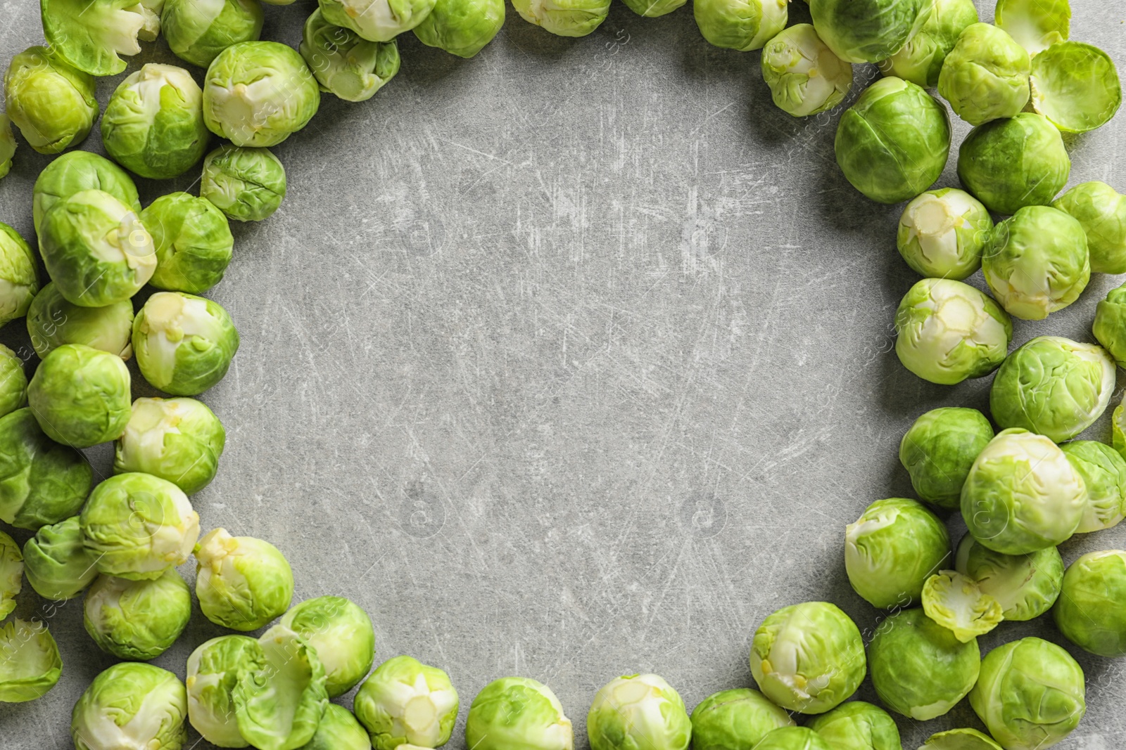 Photo of Frame made with Brussels sprouts on grey background, top view. Space for text