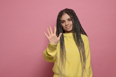 Photo of Young woman giving high five on pink background, space for text