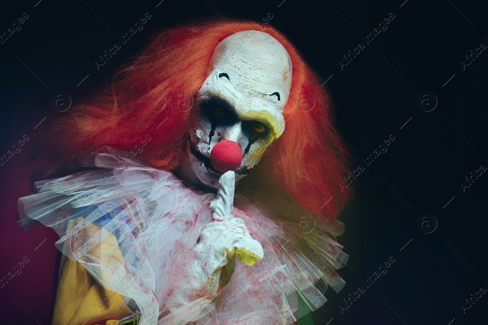 Photo of Terrifying clown on black background. Halloween party costume