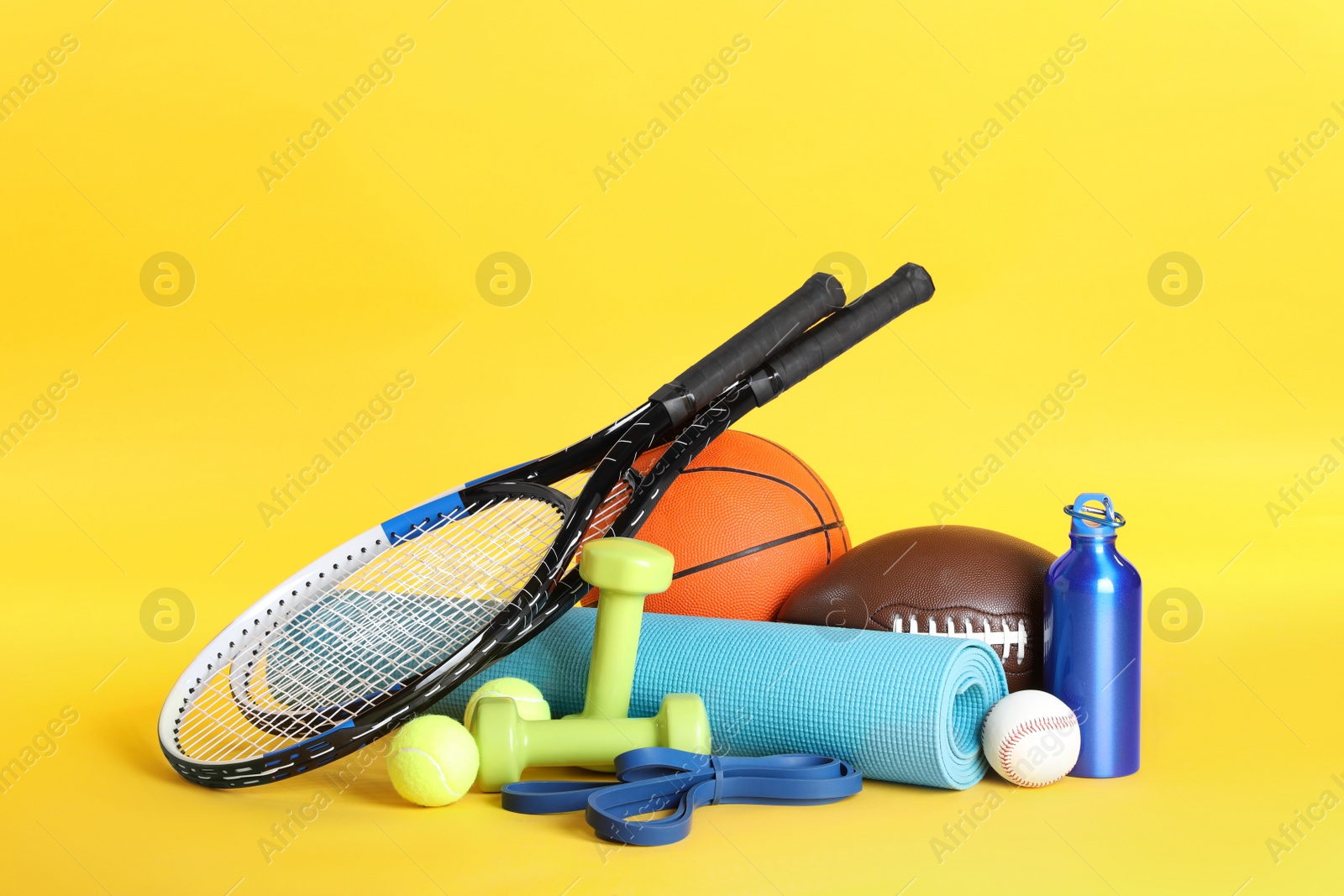 Photo of Set of different sports equipment on yellow background