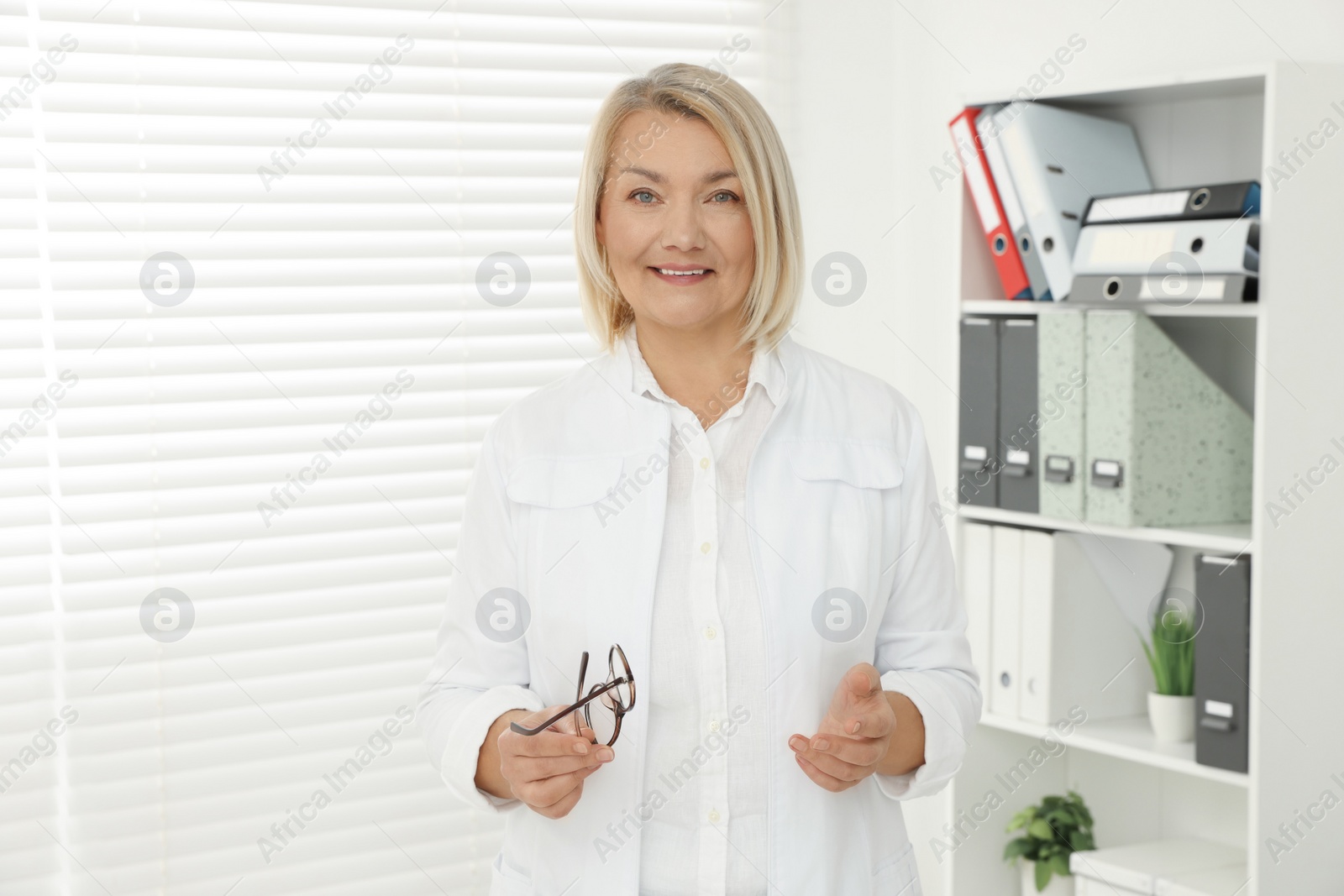 Photo of Professional doctor wearing uniform near window in clinic