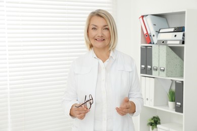 Professional doctor wearing uniform near window in clinic