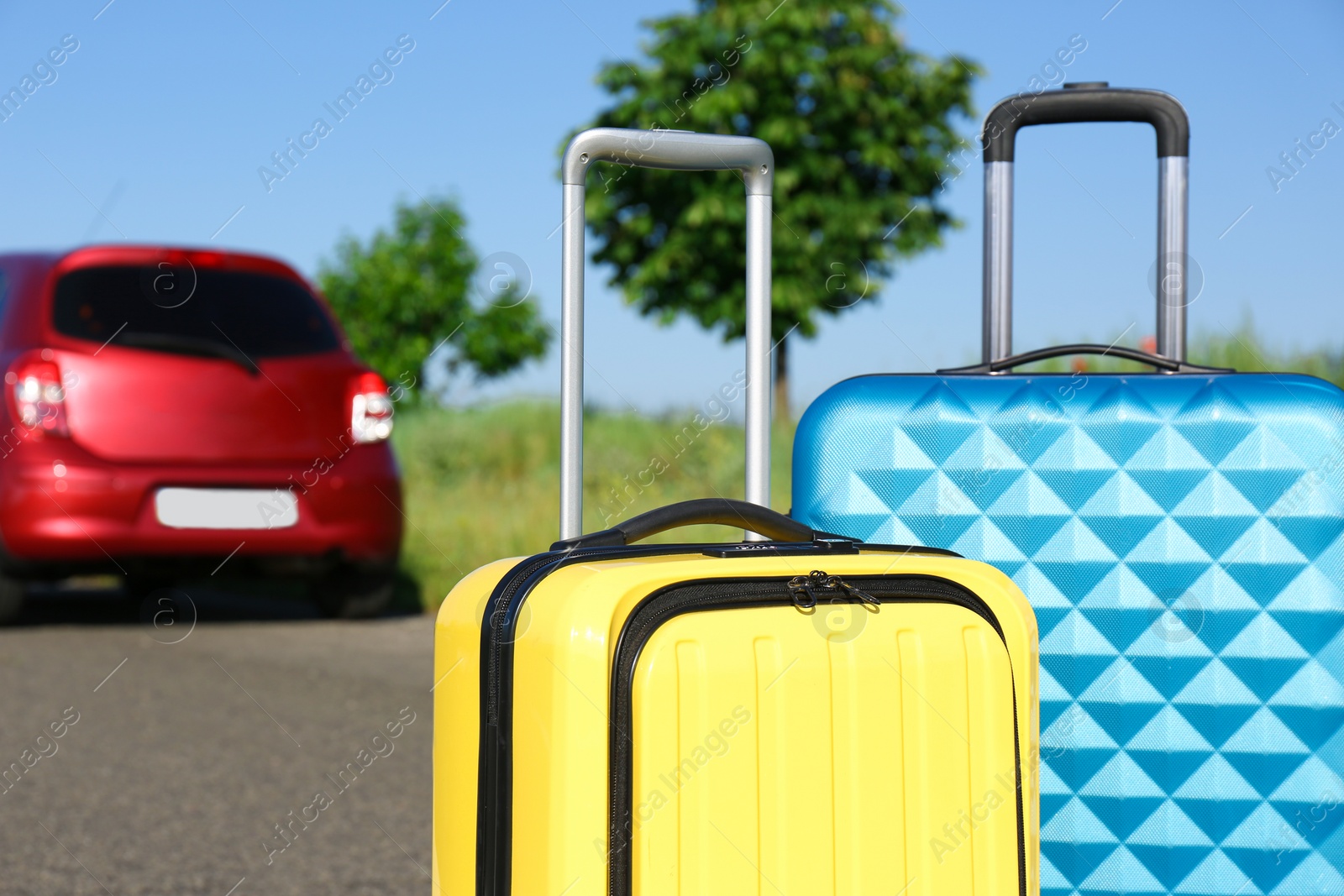 Photo of Color suitcases near family car on highway. Summer vacation