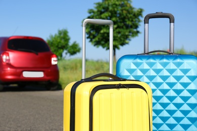 Color suitcases near family car on highway. Summer vacation