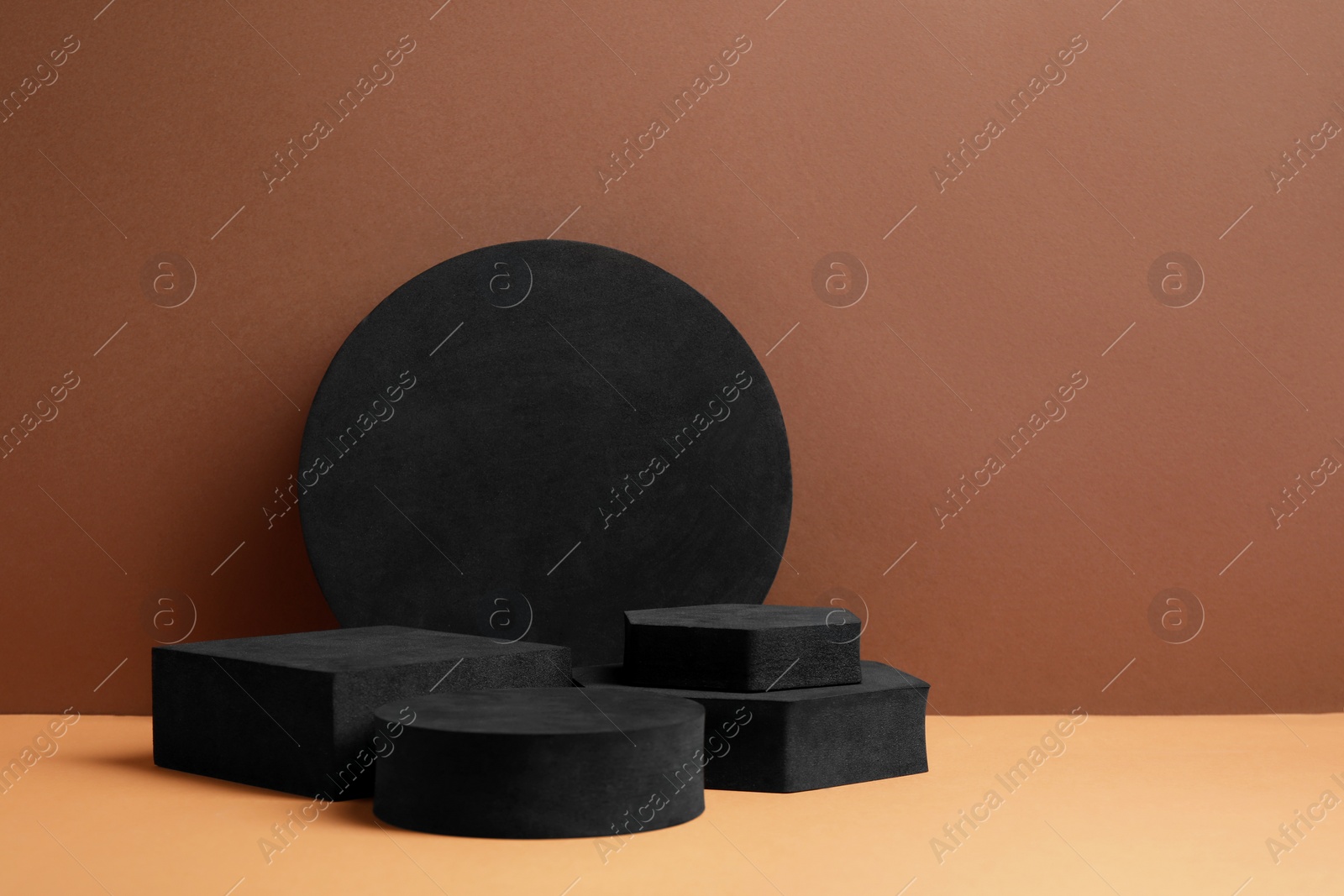Photo of Black geometric figures on brown background, space for text. Stylish presentation for product
