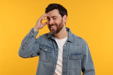 Photo of Portrait of handsome man laughing on yellow background