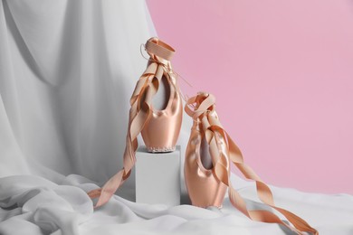 Photo of Ballet shoes. Stylish presentation of elegant pointes on pink background