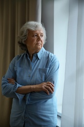 Photo of Portrait of elderly woman near window indoors