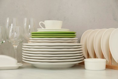 Photo of Clean plates, glasses, cup and bowl on white marble table